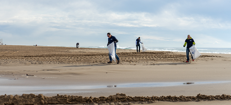 Tres empleados de Storopack durante una limpieza en la playa