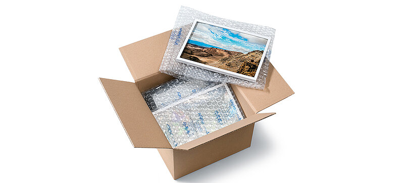 Una caja de cartón que contiene un marco de fotos y acolchados de aire