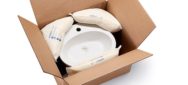 
			Una caja de cartón con un lavabo y almohadillado de espuma