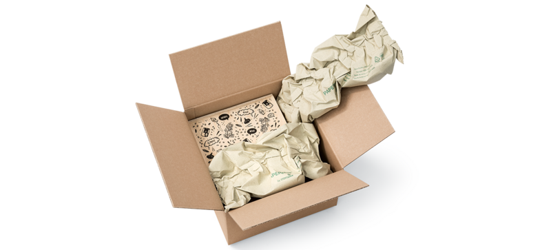 Una caja de cartón que contiene una caja de madera y tiras de almohadillados de papel de hierba