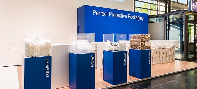 
			Un estand de feria de Storopack con cuatro vitrinas azules