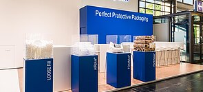 
		Un estand de feria de Storopack con cuatro vitrinas azules