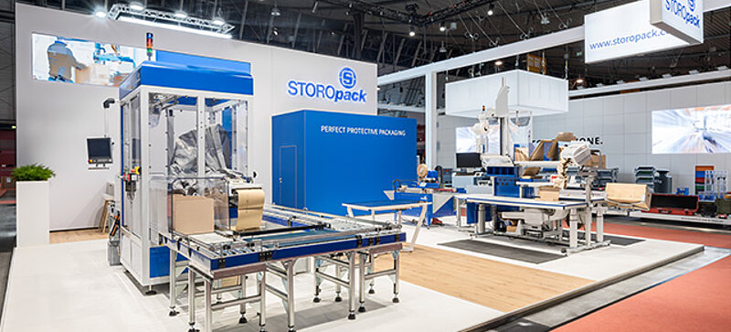 
	  Un estand de feria de Storopack con cuatro vitrinas azules