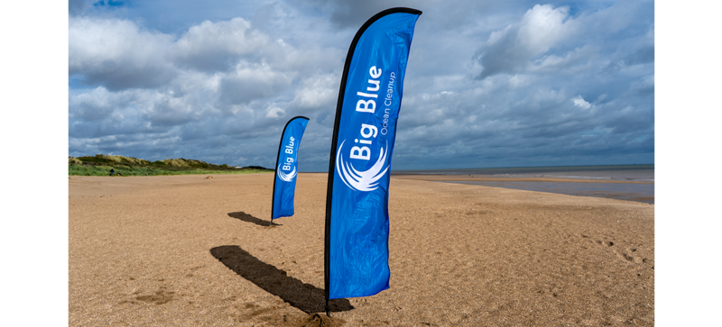 Hay dos banderas de playa del proyecto Big Blue Ocean Cleanup en la playa
