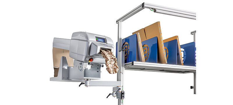 A paper machine is mounted on a swivel arm attached to a packing table.