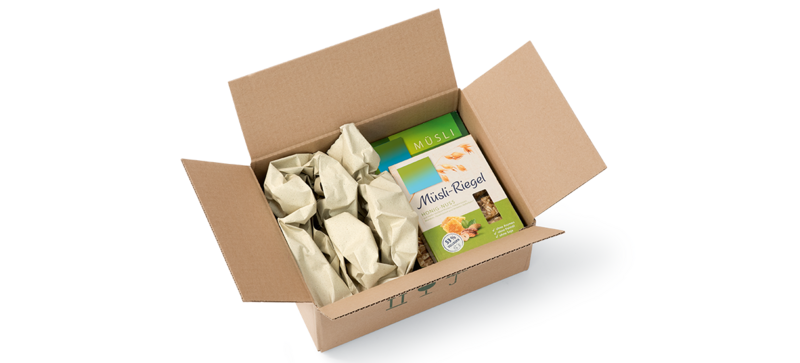 Una caja de cartón que contiene un paquete de muesli y tiras de almohadillados de papel de hierba