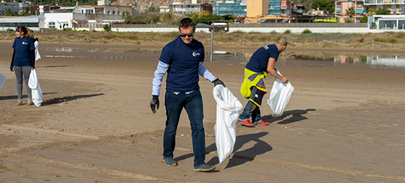 Tres empleados de Storopack durante una limpieza en la playa