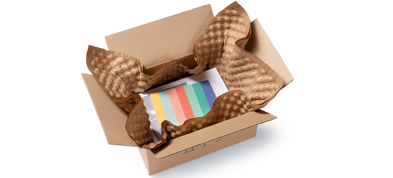 Una caja de cartón con productos y hojas de papel de burbujas de color marrón