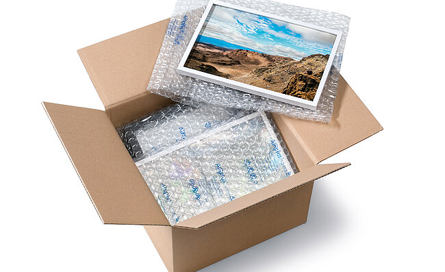 Una caja de cartón que contiene un marco de fotos y acolchados de aire