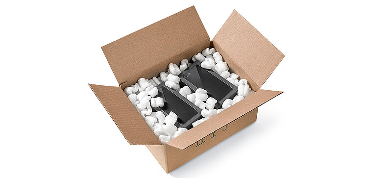 Una caja de cartón que contiene smartphones y chips de embalaje de bioplástico en forma de S