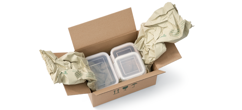 Una caja de cartón que contiene contenedores de almacenamiento de alimentos y tiras de almohadillados de papel de hierba