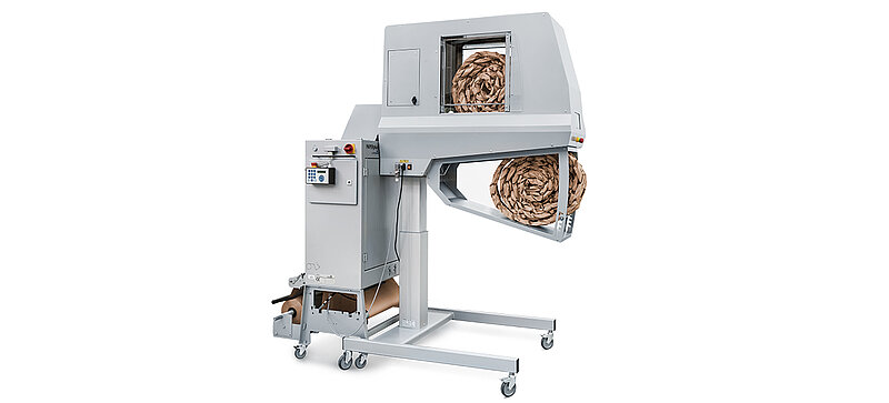 Una máquina gris que fabrica tiras de almohadillados de papel marrón